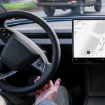 Салон електромобіля Tesla з активним інтерфейсом автопілота FSD Supervised на центральному екрані під час руху вулицями міста