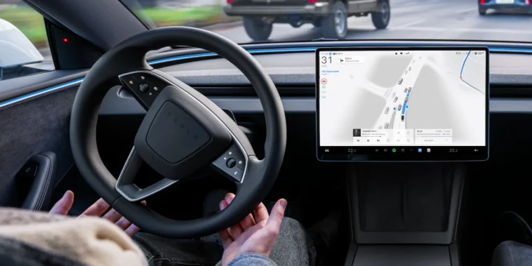 Салон електромобіля Tesla з активним інтерфейсом автопілота FSD Supervised на центральному екрані під час руху вулицями міста