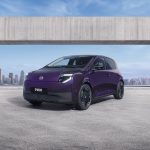 Компактний міський електромобіль Nissan PIXO фіолетового кольору Wonder Purple із піксельною LED-оптикою на міській вулиці