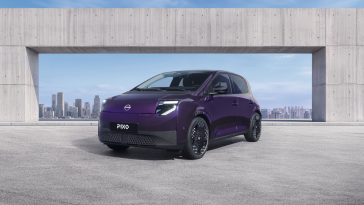Компактний міський електромобіль Nissan PIXO фіолетового кольору Wonder Purple із піксельною LED-оптикою на міській вулиці